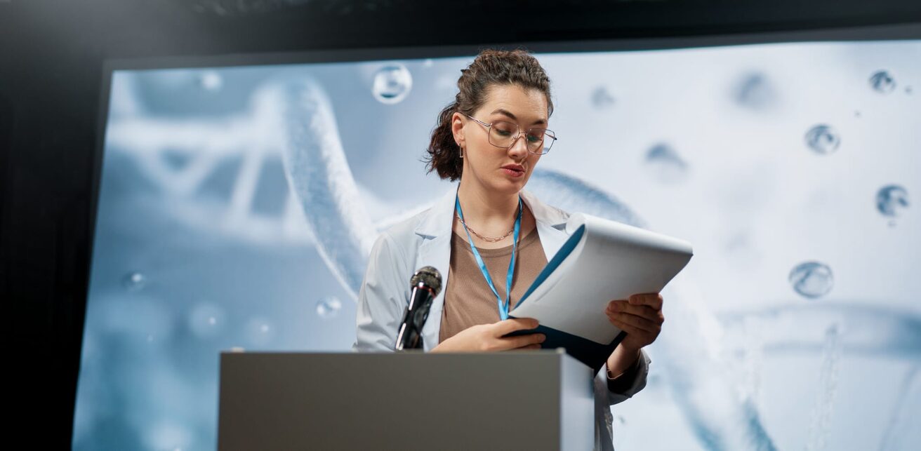 Speaker presenting in front of a large screen